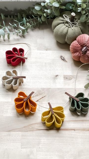 a garland made with homemade felt leaves. the leaves are made with a collection of loops hot glued together. then a needle and thread goes through the base of each leaf to strand them together.